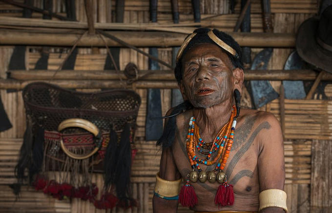 Trên ảnh là thủ lĩnh của bộ lạc săn đầu người ở Naga. Người đàn ông này nổi bật với khuyên tai được làm từ một chiếc sừng lớn, trên cổ đeo dây chuyền truyền thống. Phía sau lưng ông là vũ khí mà người dân ở đây từng sử dụng trong các trận chiến.