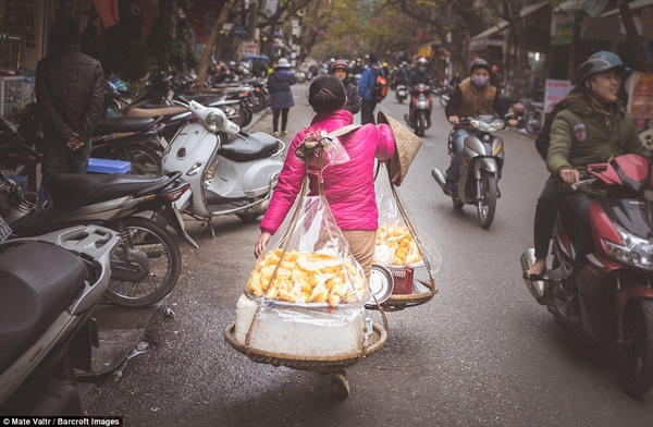 Trên phố, một chị rảo bước gánh hàng bánh đi rong trong tiết trời se lạnh.