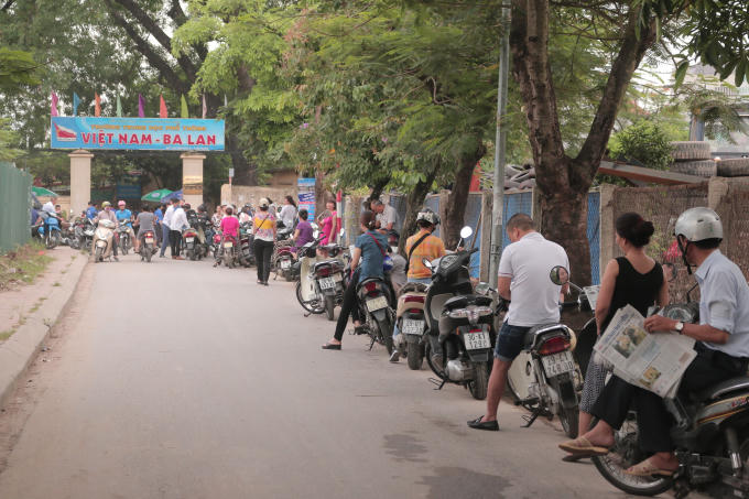 Người nhà thí sinh xếp hàng dài ngoài khu vực thi.