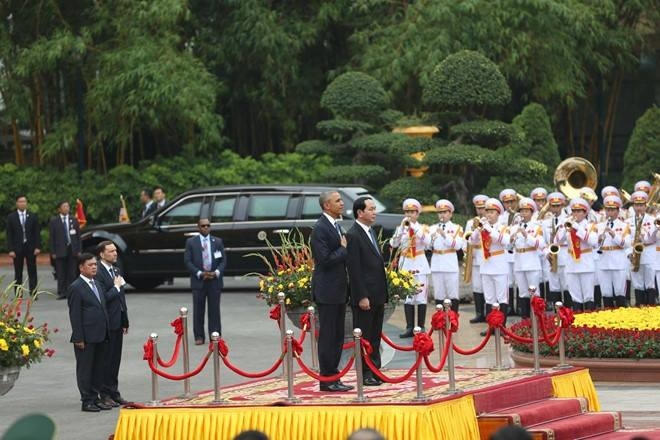 Chủ tịch nước Trần Đại Quang và Tổng thống Obama bước lên bục chào cờ. Quân nhạc cử Quốc ca Mỹ. Tổng thống Obama nghiêm trang đặt tay lên trái tim. Tiếp đó, quân nhạc cử Quốc ca Việt Nam.