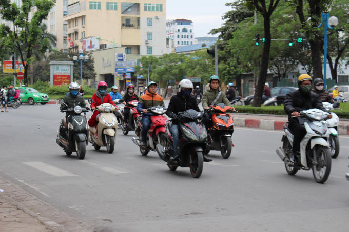 Nhiều người ra đường phải mặc áo khoác, khăn quàng để đối phó với cái rét đầu mùa.