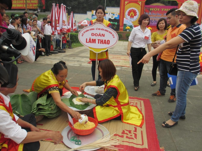 Với bàn tay khéo léo, những nghệ nhân của đội Lâm Thao đang trổ tài gói bánh chưng dâng lên các Vua Hùng trong sự cổ vũ nhiệt tình của khán giả. (Ảnh: Thu Hường)