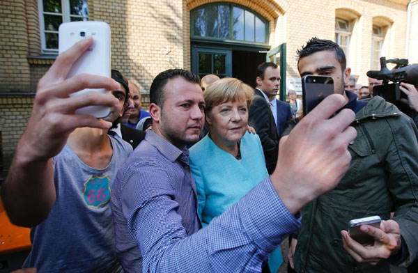 Người tị nạn Syria và Iraq selfies với Thủ tướng Đức Angela Merkel bên ngoài một Văn phòng Liên bang về di cư và người tị nạn ở Berlin.