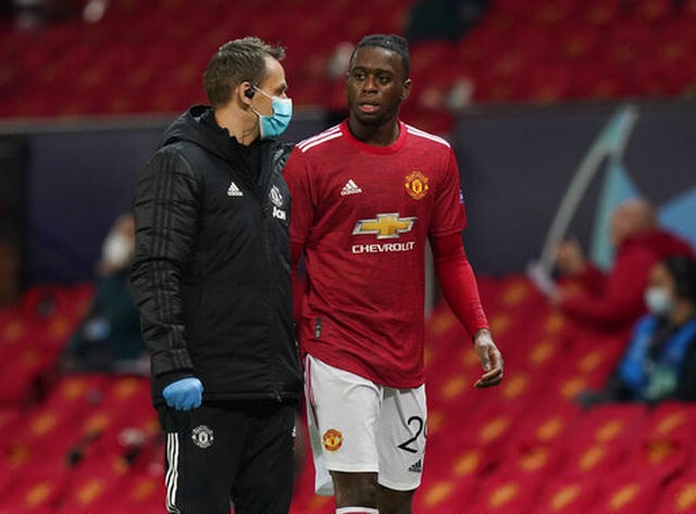 Wan-Bissaka (phải) có vẻ đã bị đau nên được rút khỏi sân ở phút 58, anh đã không lên khán đài mà đi vào đường hầm cùng một trợ lý trong đội