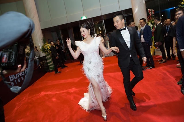 Lý Nhã Kỳ được ông bầu Vũ Khắc Tiệp cầm tay trên thảm đỏ.