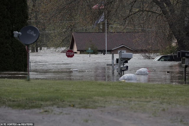 Các phương tiện và biển hiện giao thông chìm trong nước lũ ở Sanford, Michigan (Ảnh: Reuters)