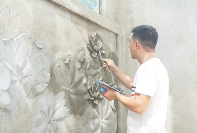 Anh Dương Tùng dùng chiếc bay để tạo hình cụm hoa sen bằng xi măng cho một công trình tại xã Nghi Phú, thành phố Vinh, Nghệ An.