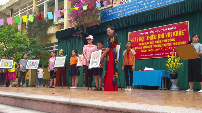 Cô Nguyễn Thị Thanh Mai - Hiệu trường trường tiểu học Tân triều trao bức tranh cho bà Thu Hương (một phụ huynh học sinh) trong buổi đấu giá.