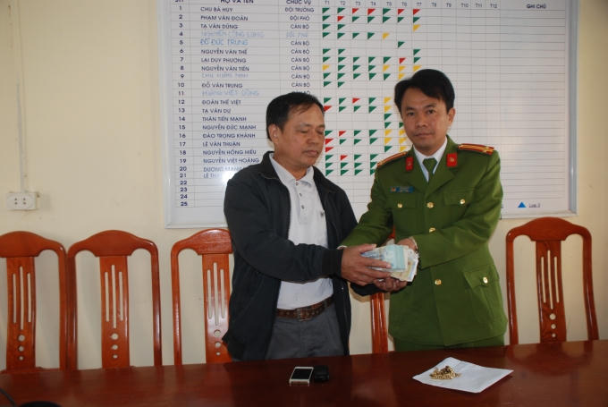 Ông Nguyễn Văn Hoan (bên trái) ở xã Tự Lạn, Việt Yên nhận lại tài sản bị mất từ cán bộ công an huyện Việt Yên.