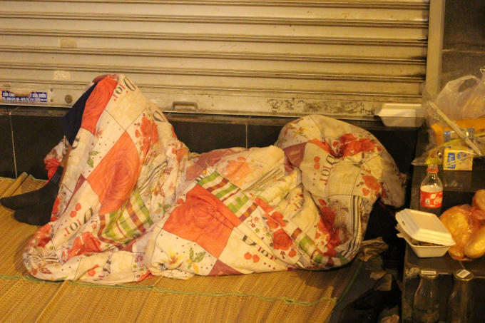 Một người đ&agrave;n &ocirc;ng tr&ugrave;m chăn k&iacute;n m&iacute;t ngủ tr&ecirc;n đường Phủ Do&atilde;n.