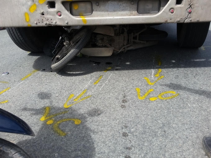 Chiếc xe máy kẹt cứng dưới gầm xe container.