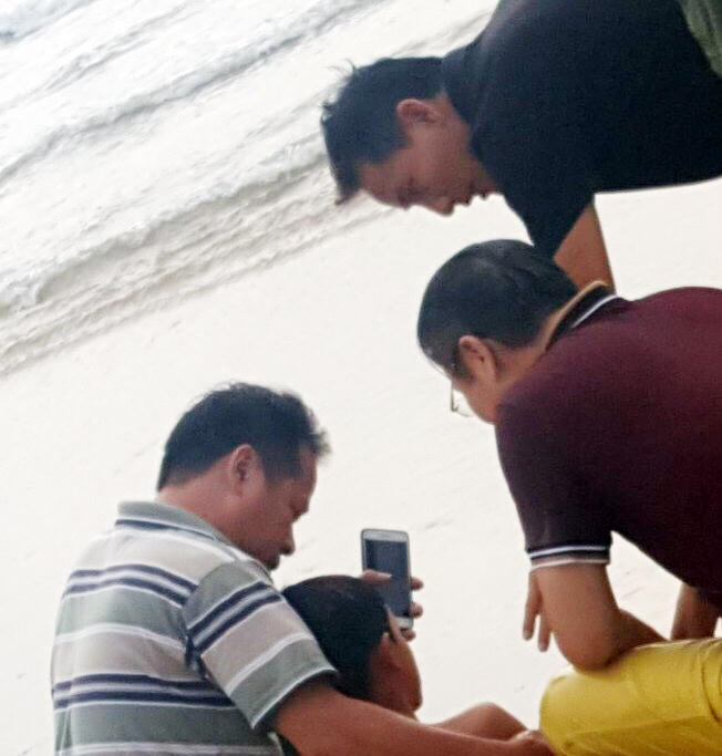 Anh Dương Kim Sơn (quần vàng) và người dân sơ cứu cho cháu bé sau khi được vớt lên sau khi đuối nước.