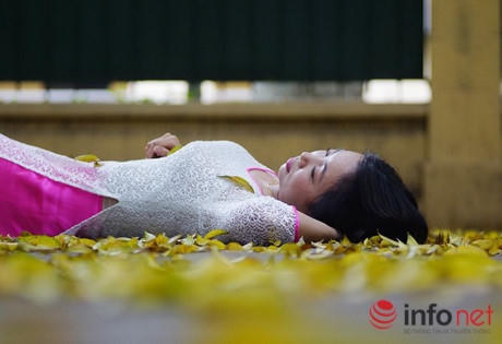 Những cô gái trẻ thả mình trên thảm lá vàng.