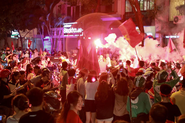 Pháo sáng được các cổ động viên đốt rực một góc phố.