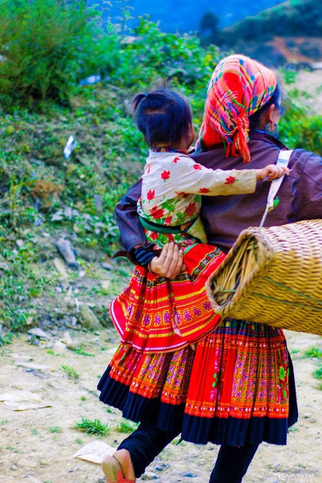 Đứa bé tinh nghịch trên lưng bà. (Ảnh: Đức Chiến). Bé gái nhỏ duyên dáng trước bộ quần áo mới.(Ảnh: Đức Chiến).