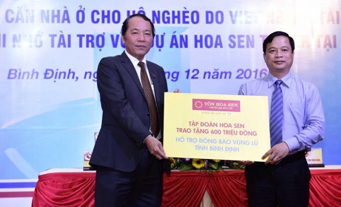 Ông Trần Ngọc Chu - Phó Chủ tịch HĐQT, Tổng giám đốc Tập đoàn Hoa Sen trao bảng tượng trưng ủng hộ lũ lụt đồng bào tỉnh Bình Định cho ông Nguyễn Tuấn Thanh - PCT UBND Tỉnh.