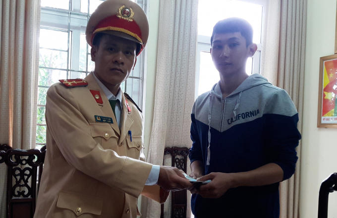 Anh Hoàng vui mừng nhận lại chiếc ví cùng toàn bộ tài sản từ tay thượng úy Phạm Văn Anh.