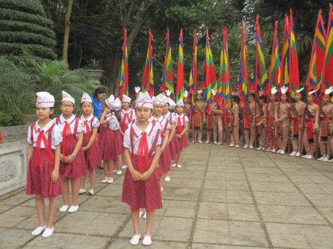 Các em thiếu nhi cùng 100 thanh niên con Lạc cháu Hồng rước cờ trong nghi lễ Giỗ Tổ. (Ảnh: Thu Hường).