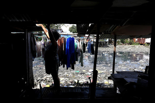 Những căn nhà lụp xụp, tối om xung quanh con kênh.