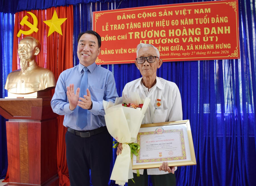 Ông Lữ Quang Ngời – Phó Bí thư Tỉnh ủy, Chủ tịch UBND tỉnh Cà Mau trao Huy hiệu 60 năm tuổi Đảng và tặng hoa chúc mừng đảng viên Trương Hoàng Danh.