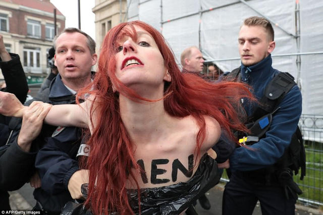 Một phụ nữ ngực trần phản đối ứng viên Le Pen bị cảnh sát bắt giữ. (Ảnh: AFP)