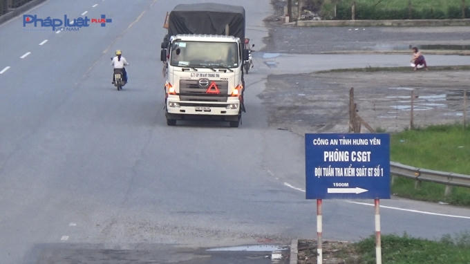 Xe tải và xe máy cùng nhau đi ngược chiều.