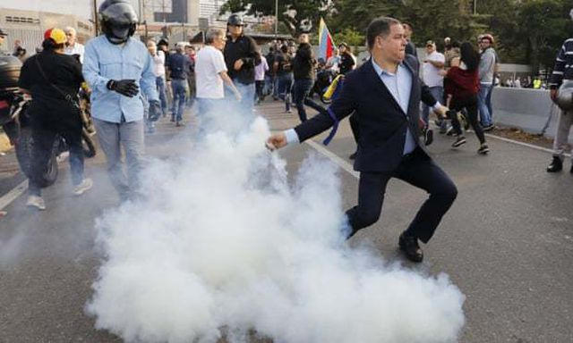 Người biểu tình phản đối chính phủ Venezuela ném bom khói vào lực lượng an ninh ở căn cứ không quân  La Carlota. (Ảnh: AFP)