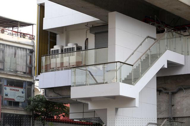 Một cầu thang bộ dẫn lên nhà ga nằm trên đường Nguyễn Trãi có lan can kính đã lắp xong, các thiết bị khác cũng được lắp đặt vào vị trí.