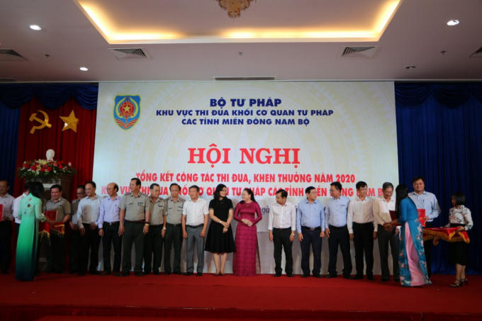 lãnh đạo Bộ Tư pháp tặng hoa bà trao bản cam kết thi đua cho lãnh đạo sở, ngành Tư pháp khu vực MĐNB