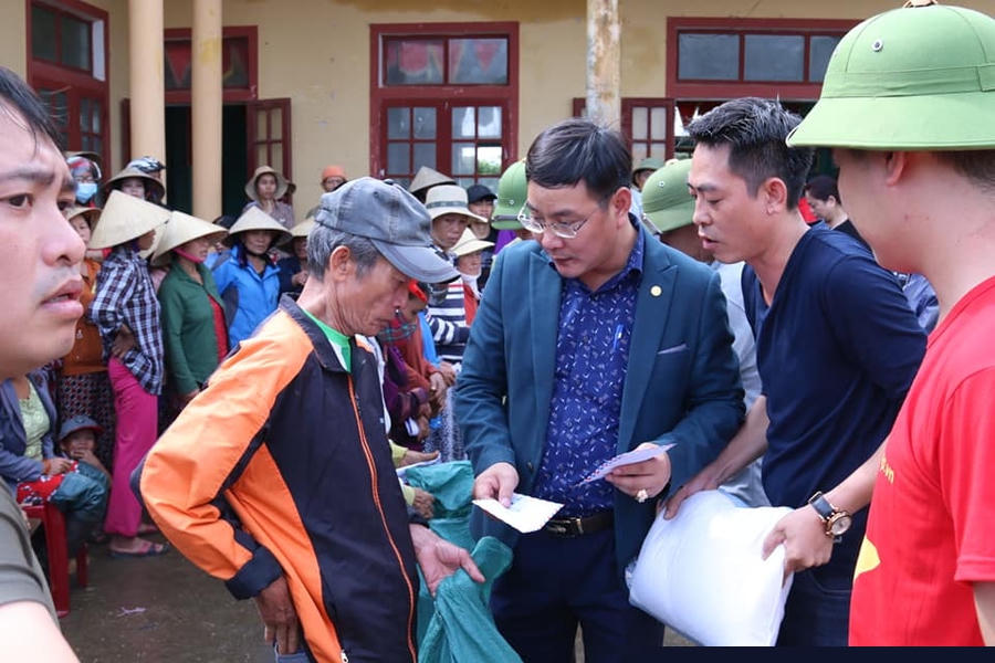 Ông Nguyễn Ngọc Quyết (ở giữa) - Tổng Biên tập Tạp chí điện tử Hòa Nhập trao quà cứu trợ cho bà con nhân dân vùng lũ thôn Phú Hòa, xã Phú Thuỷ, huyện Lệ Thuỷ, Quảng Bình.