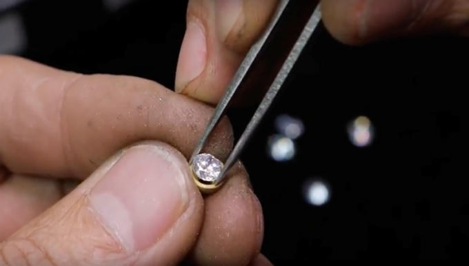 Huy hiệu cài áo được mạ vàng 18K, ở giữa huy hiệu đính một viên đá chính là Swarovski, có 4 màu cho 4 nhóm. Ảnh: HOÀI AN.