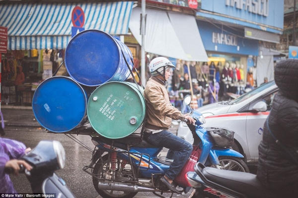 Người người ra đường chở thùng nọ thùng kia dù trời đang mưa.