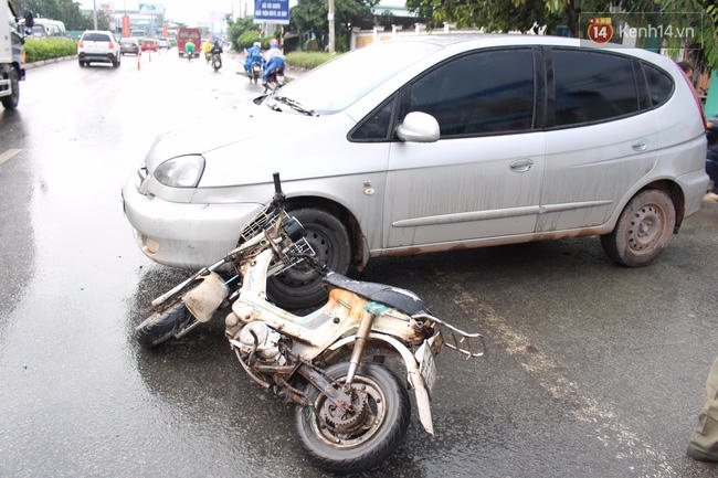 Xe máy của người chồng chở vợ đang mang thai dính chặt vào ô tô.