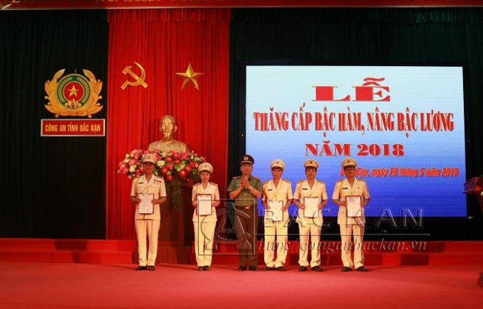 Đại tá Dương Văn Tính – PGĐ Công an tỉnh trao quyết định và gắn quân hàm Trung tá cho các đồng chí đến niên hạn (Ảnh: Conganbackan.vn).