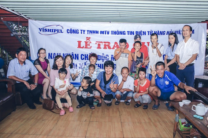 Người lao động Công ty VISHIPEL chụp ảnh lưu niệm cùng chị Hương và các bạn nhỏ tại Trại nấm Thiện Giao.