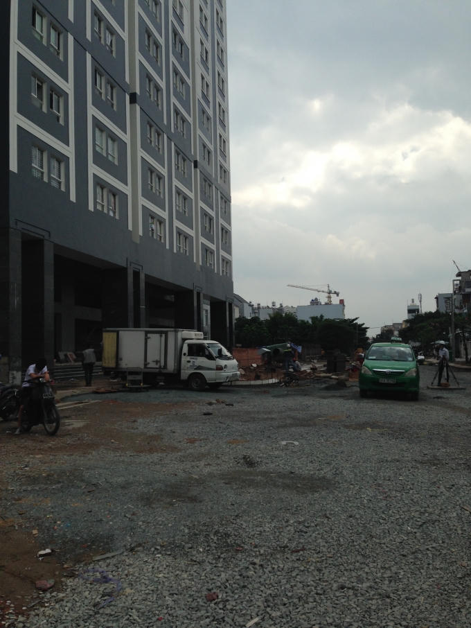 Trước cửa mặt tiền chung cư Dream Home Luxury vẫn còn đá dăm, xe cộ phục vụ xây dựng.