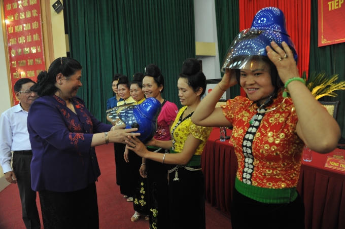 Bà Tòng Thị Phóng - Phó chủ tịch Quốc Hội đang trao mũ cho phụ nữ dân tộc thái tại Sơn La.