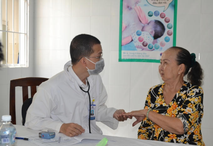 Các bác sĩ tận tình giúp đỡ một cụ già neo đơn vào khám bệnh.