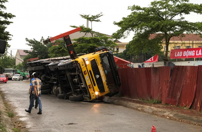 Chiếc xe bị lật nghiêng khiến toàn bộ phần cần cẩu đổ sập về phía công trình đang xây dựng.