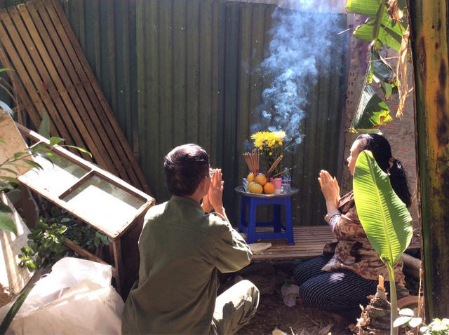 Vợ chồng ông Quy phải vái vọng cụ kỵ, ông bà qua hàng rào tôn