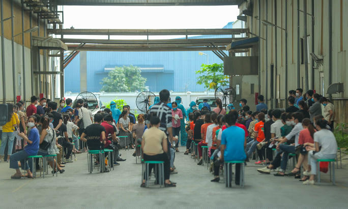 Hàng ngàn công nhân được xếp hàng ngay ngắn chờ các nhân viên y tế lấy mẫu xét nghiệm Covid-19 tại KCN Quang Châu