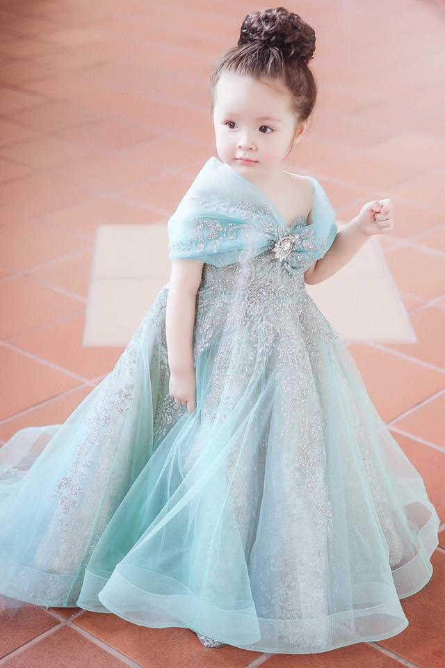 C&ocirc; b&eacute; l&iacute; lắc, đ&aacute;ng y&ecirc;u trong chiếc v&aacute;y m&agrave;u xanh bồng bềnh v&agrave; đ&ocirc;i mắt to tr&ograve;n v&ocirc; c&ugrave;ng đ&aacute;ng y&ecirc;u.