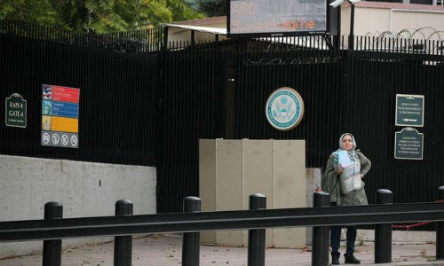 Một người phụ nữ chờ làm visa trước cổng Đại sứ quán Mỹ tại Ankara, Thổ Nhĩ Kỳ. (Ảnh: Reuters)