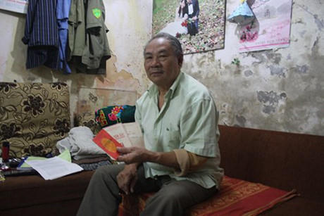 Ông Toán bên một sổ tiết kiệm còn giữ lại được.