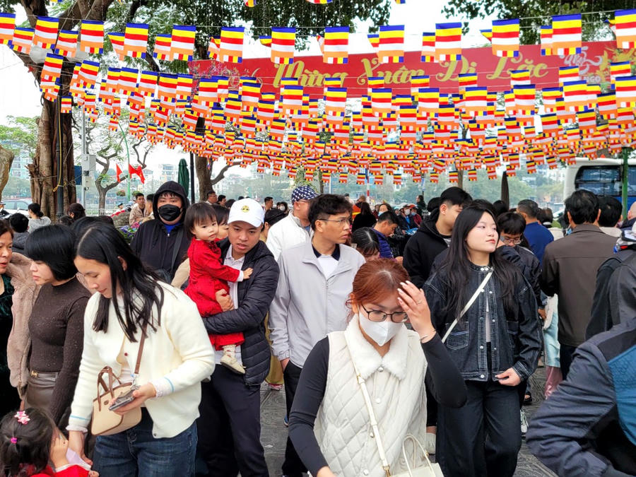 Ngay từ lối vào ven hồ, sắc đỏ của cờ Tổ quốc và sắc vàng rực rỡ của cờ Phật giáo tung bay trong gió, tạo nên một không gian vừa trang nghiêm vừa mang đậm hơi thở lễ hội. (Ảnh: Phạm Duy)