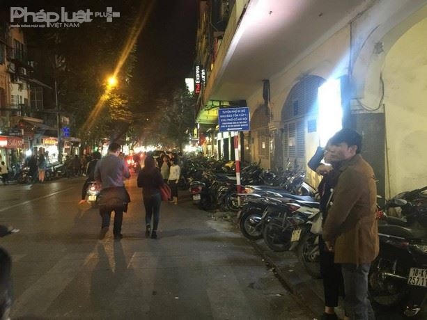 Nhiều người đứng giữa đường chèo kéo khách vào gửi xe