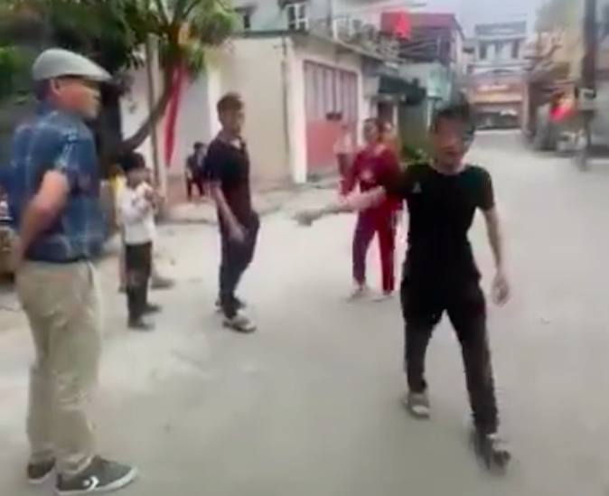 Hai người dân ra đòi tiền đỗ xe trước cổng chùa Gôi (Ảnh cắt từ clip).