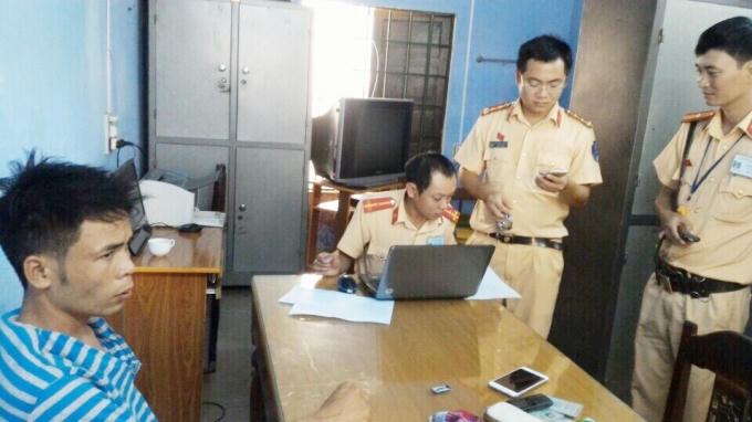 Đối tượng (góc phải) tại cơ quan công an.