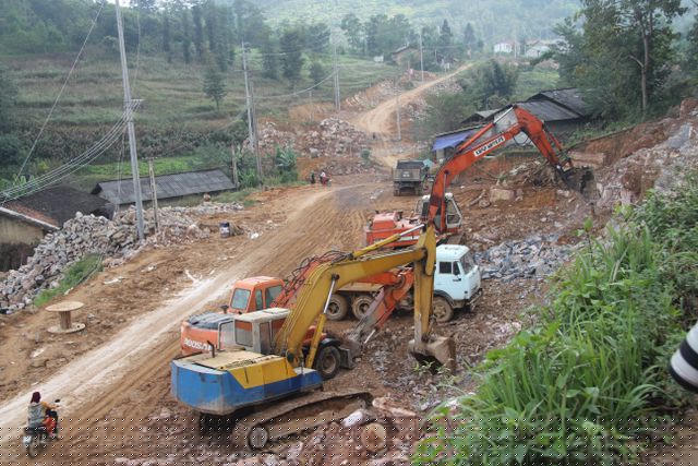 Các công nhân vẫn đang miệt mài phá núi, hoàn thiện con đường xuyên qua cánh đồng Thèn Pả (xã Lũng Cú) sau khi thu hồi ruộng canh tác của đồng bào nơi đây (Ảnh: Nguyễn Trường).