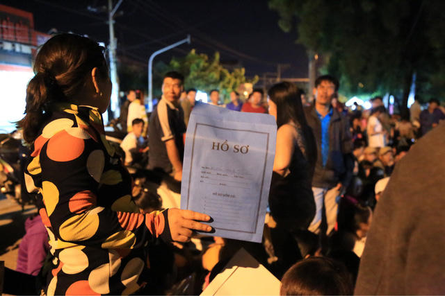 Một phụ huynh sẵn sàng bộ hồ sơ trên tay.